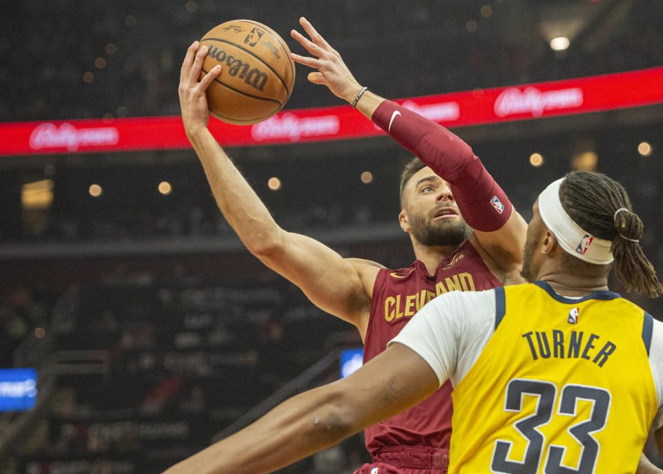 Cleveland Cavaliers' Max Strus, left, looks to shoot over Indiana Pacers' Myles Turner (33) during the first half of an NBA basketball game in Cleveland, Friday, April 12, 2024. (AP Photo/Phil Long)