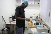 A worker with Nature's Treat Cafe prepares a parfait for a customer in Ibadan, Nigeria, Monday, May 27, 2024. Households and businesses often use polluting gasoline and diesel-run backup private generators. But as fuel prices rise, businesses like Nature's Treat Cafe face unsustainable generator costs, prompting a push for affordable solar solutions. (AP Photo/Sunday Alamba)