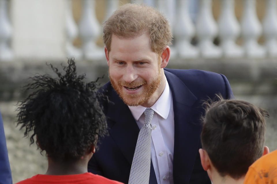 El príncipe Enrique saluda a unos niños durante una actividad oficial en el Palacio de Buckingham en Londres el 16 de enero del 2020. Su decisión de hacer una vida independiente de la realeza convulsionó a la familia real. (AP Photo/Kirsty Wigglesworth)