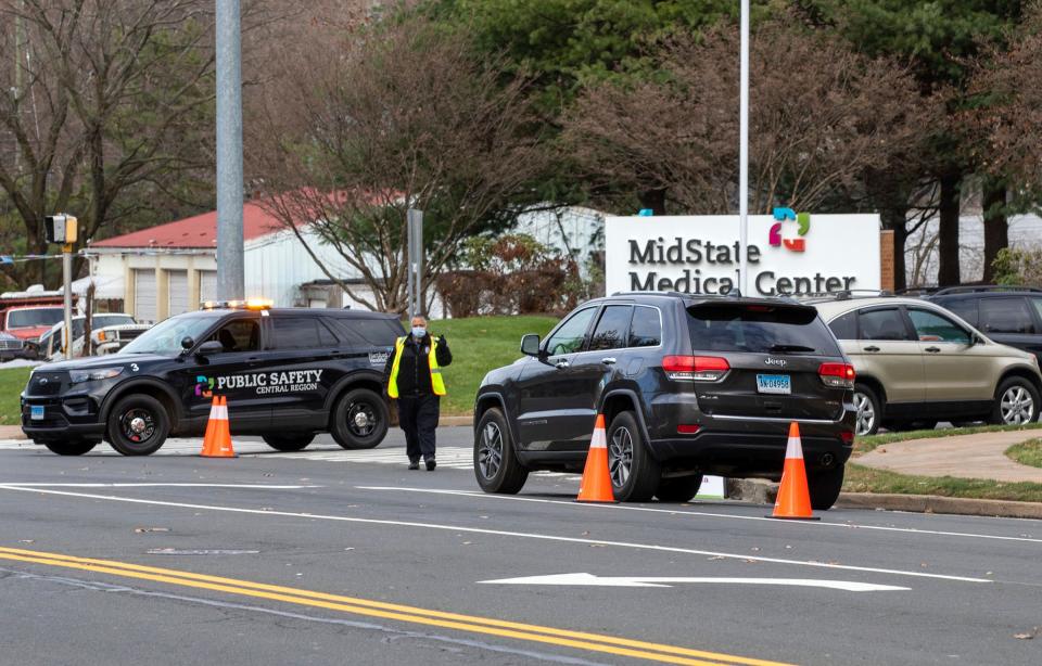 Cars wait in line at the entrance to MidState Medical Center in Meriden, Conn. to get a COVID-19 test on Thursday, Nov. 19, 2020.