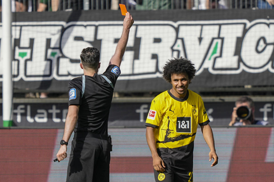 Dortmund's Karim Adeyemi, right, receives a red card from referee , right, announces the canc during the German Bundesliga soccer match between Borussia Moenchengladbach and Borussia Dortmund at the Borussia Park in Moenchengladbach, Germany, Saturday, April 13, 2024. (AP Photo/Martin Meissner)