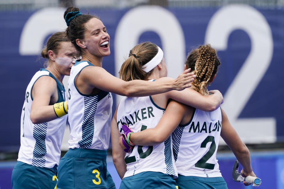 Australia's Ambrosia Malone (2) celebrates with her teammates Emily Chalker (26) and Brooke Peris after scoring on China goalkeeper Dongxiao Li during a women's field hockey match at the 2020 Summer Olympics, Monday, July 26, 2021, in Tokyo, Japan. (AP Photo/John Minchillo)