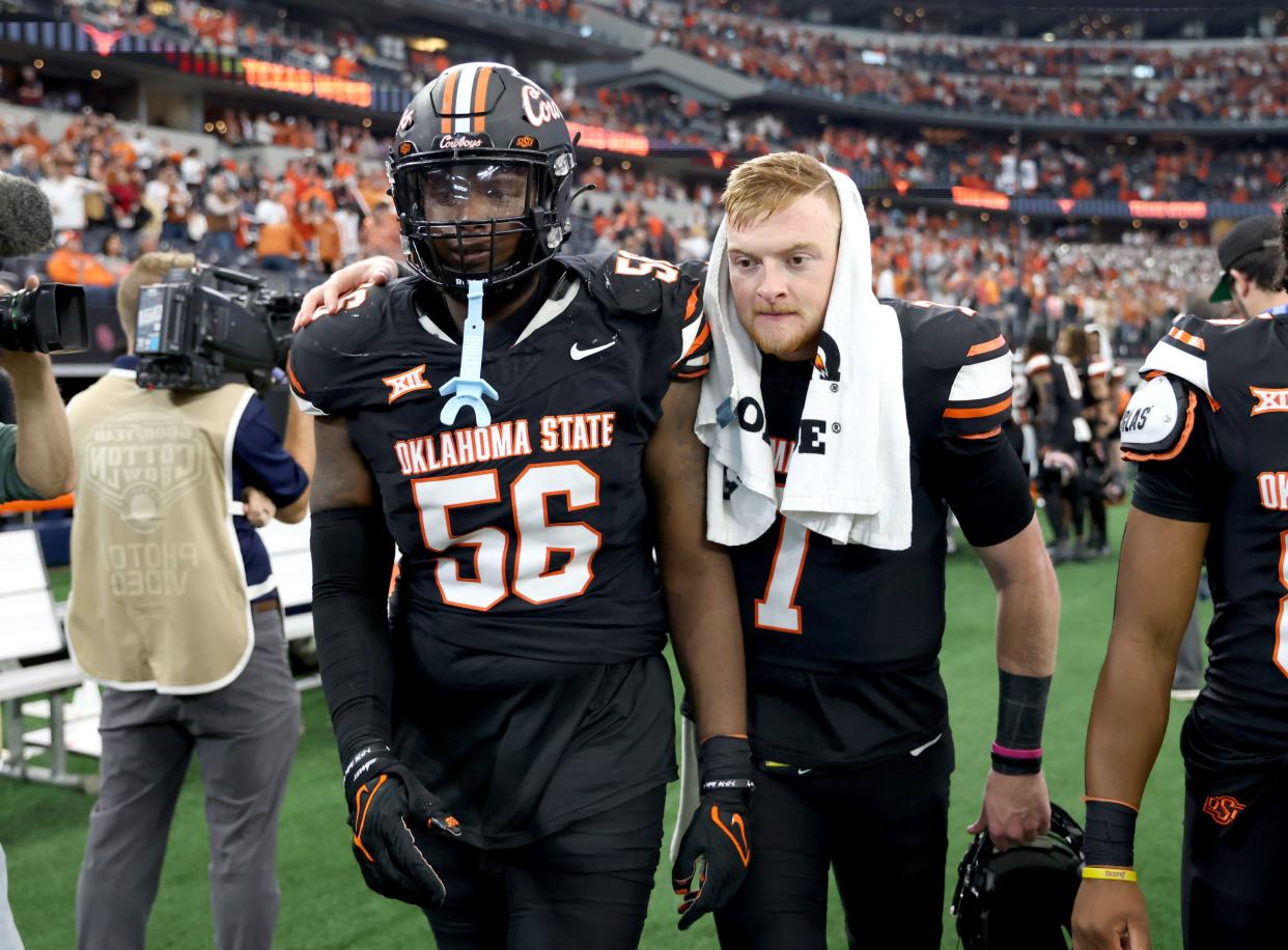 Oklahoma State's Alan Bowman (7) and Xavier Ross (56) walk off the field following the Big 12 Football Championship game between the Oklahoma State University Cowboys and the Texas Longhorns at the AT&T Stadium in Arlington, Texas, Saturday, Dec. 2, 2023.