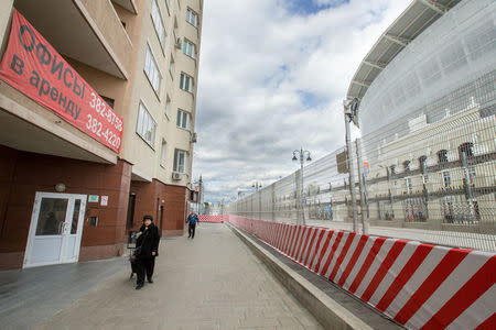 People walk near the Krylova Street, Number 27 apartment building, located in front of the Ekaterinburg Arena in the city of Yekaterinburg, the host city for the 2018 FIFA World Cup, Russia June 4, 2018. REUTERS/Alexei Kolchin