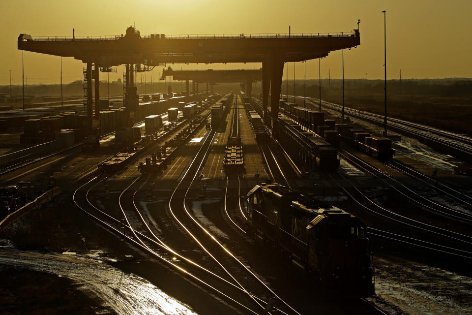 FILE - In this Friday, Dec. 20, 2019, file photo, shipping containers are offloaded at a BNSF Railway intermodal facility as the sun sets in Edgerton, Kan. Federal regulators say the nation’s four largest railroads, Union Pacific, BNSF, CSX and Norfolk Southern, shouldn’t be able to exclude all the details of their conversations from a lawsuit challenging the way they set rates in the past. (AP Photo/Charlie Riedel, File)