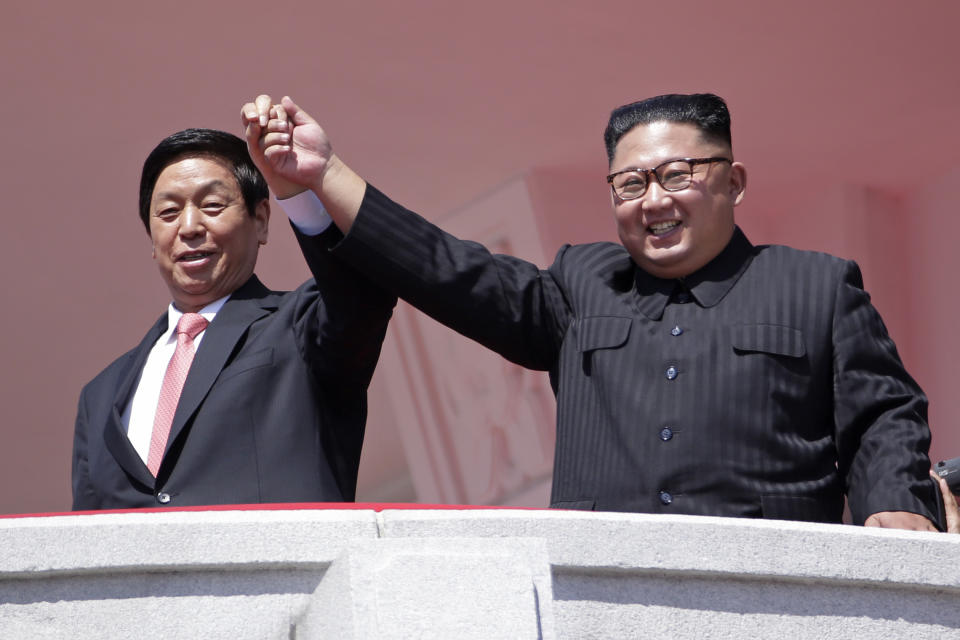 North Korean leader Kim Jong Un, right, raises hands with China's third-highest ranking official, Li Zhanshu, during a parade for the 70th anniversary of North Korea's founding day in Pyongyang, North Korea, Sunday, Sept. 9, 2018. North Korea staged a major military parade, huge rallies and will revive its iconic mass games on Sunday to mark its 70th anniversary as a nation. (AP Photo/Kin Cheung)