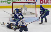 Vancouver Canucks' Antoine Roussel (26) scores against St. Louis Blues goalie Jordan Binnington (50) during second-period NHL Western Conference Stanley Cup playoff hockey game action in Edmonton, Alberta, Friday, Aug. 21, 2020. (Jason Franson/The Canadian Press via AP)