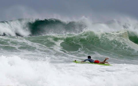 Mitchell Nugent paddles a board toward waves near Crystal Beach as Tropical Storm Gordon churns the Gulf of Mexico - Credit: Devon Ravine