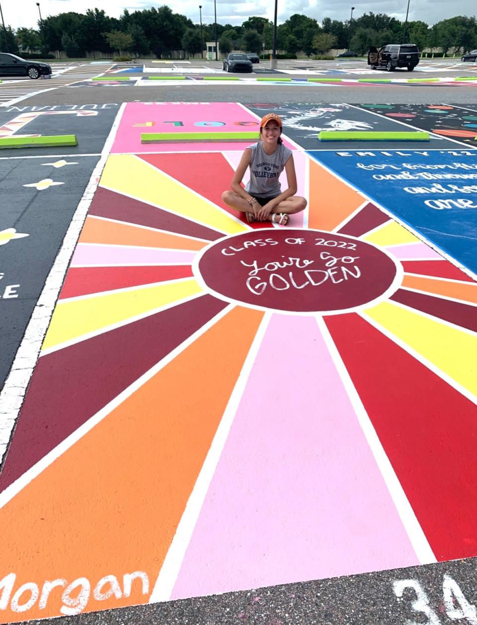 Morgan Lamb sits in the middle of her parking space, which she decorated with her father when she was a senior a few years ago. Lamb's mother, Tania, posted a popular how-to guide for other students and parents looking to go to town for the annual tradition.