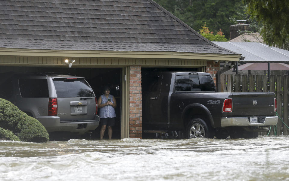 A woman looks at the flooded road in the Lochshire neighborhood Friday, Sept. 20, 2019, in Huffman, Texas. Emergency workers used boats Friday to rescue about 60 residents of a Houston-area community still trapped in their homes by floodwaters following one of the wettest tropical cyclones in U.S. history. (Godofredo A. Vásquez/Houston Chronicle via AP)