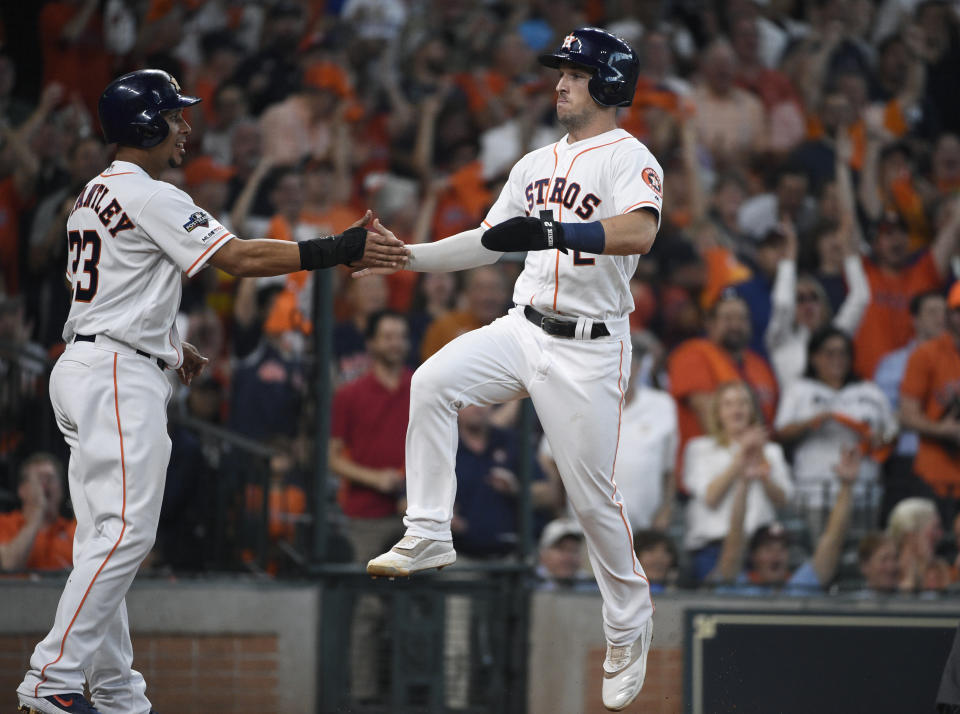 Houston Astros' Alex Bregman (2) celebrates with teammate Michael Brantley (23) as he scores against the Tampa Bay Rays in the fifth inning during Game 1 in baseball's American League Division Series in Houston, Friday, Oct. 4, 2019. (AP Photo/Eric Christian Smith)