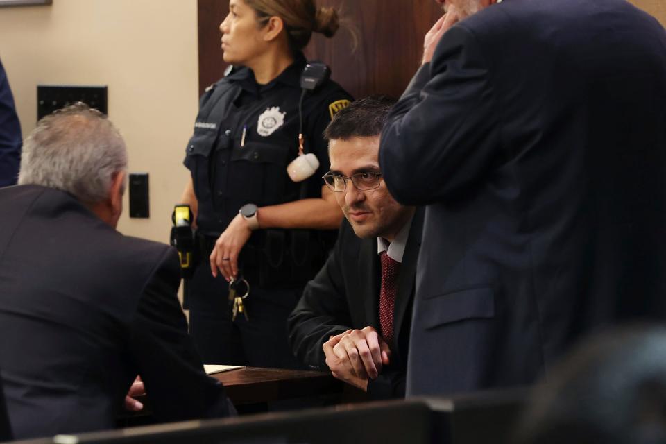 Former U.S. Border Patrol Juan David Ortiz talks with one of his attorneys, Joel Perez, before the start of the first day of his trial, Monday, Nov. 28, 2022.