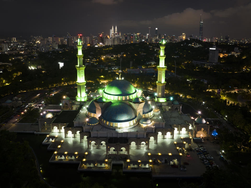 Wilayah Mosque are light up with the background of city skylines on the eve of the Ramadan in Kuala Lumpur, Malaysia, Saturday, April 2, 2022. The Muslim holy month of Ramadan — when the faithful fast from dawn to dusk — has begun in much of the Middle East, where Russia’s invasion of Ukraine has sent energy and food prices soaring. Muslims follow a lunar calendar and a moon-sighting methodology can lead to different countries declaring the start of Ramadan a day or two apart. (AP Photo/Vincent Thian)