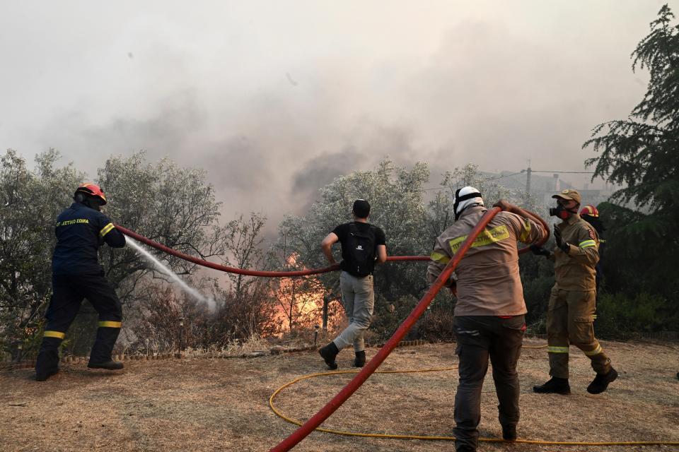 Firefighters and volunteers try to extinguish a wildfire in the town of Nea Anchialos, near Volos city, central Greece (AP)