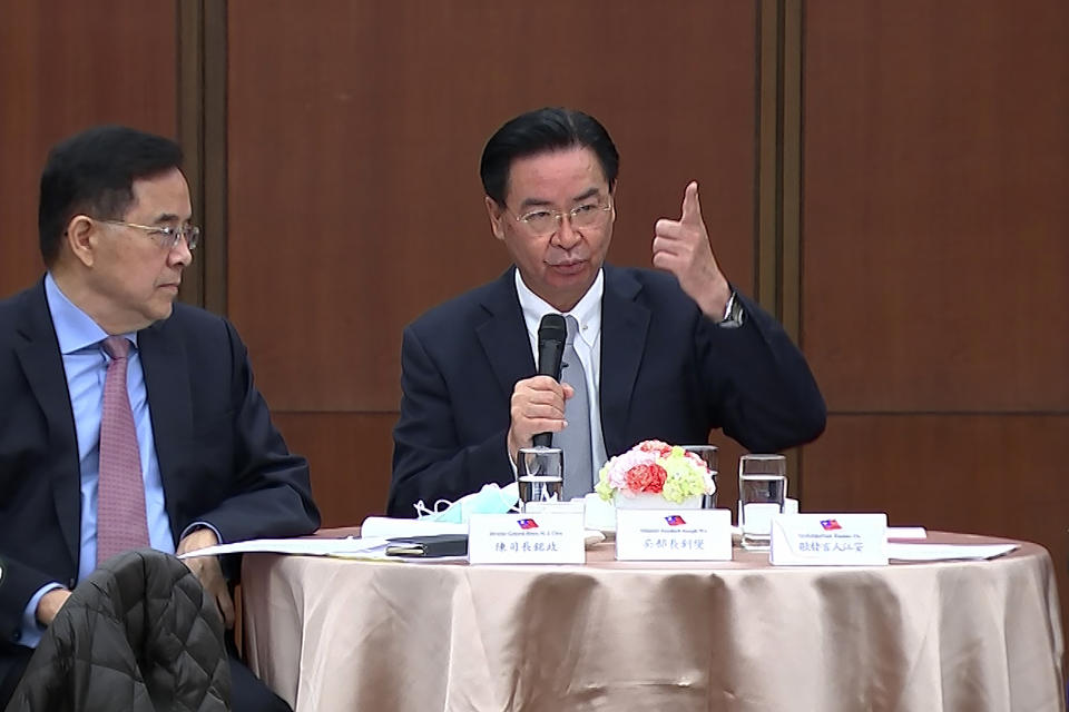 Taiwanese Foreign Minister Joseph Wu, right, speaks during a briefing Wednesday, April 7, 2021, in Taipei, Taiwan. Wu said that China's attempts at conciliation and military intimidation are sending "mixed signals" to people on the island China claims as its own territory to be won over peacefully or by force. (AP Photo/Wu Taijing)