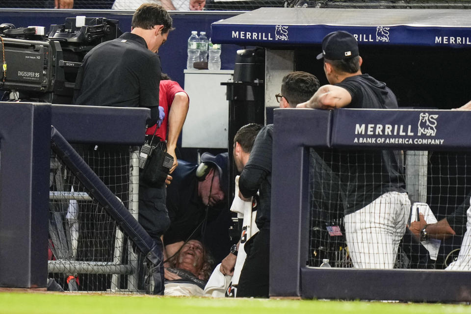 A camera operator who was injured on a throwing error by Baltimore Orioles' Gunnar Henderson receives attention during the fifth inning of the Orioles' baseball game against the New York Yankees on Wednesday, July 5, 2023, in New York. (AP Photo/Frank Franklin II)