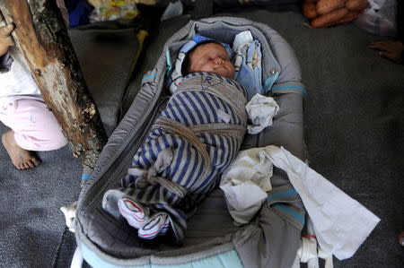 Twenty day-old baby girl, born to Syrian parents at a refugee camp, is seen in a tent at a makeshift camp for migrants and refugees at the Greek-Macedonian border near the village of Idomeni, Greece, April 25, 2016. REUTERS/Alexandros Avramidis