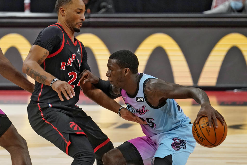 Miami Heat guard Kendrick Nunn (25) pushes off Toronto Raptors guard Norman Powell (24) as he drives up the court during the second half of an NBA basketball game Wednesday, Jan. 20, 2021, in Tampa, Fla. (AP Photo/Chris O'Meara)