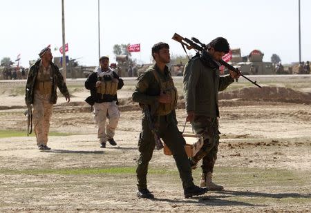 Shiite fighters walk with their combat gear in Salahuddin province, March 4, 2015. REUTERS/ Mahmoud Raouf