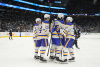 Buffalo Sabres defenseman Owen Power (25) is greeted by teammates after scoring against the Seattle Kraken, including left wing Zach Benson (9), center Dylan Cozens (24) and defenseman Henri Jokiharju (10) during the second period of an NHL hockey game Monday, March 18, 2024, in Seattle. (AP Photo/Lindsey Wasson)