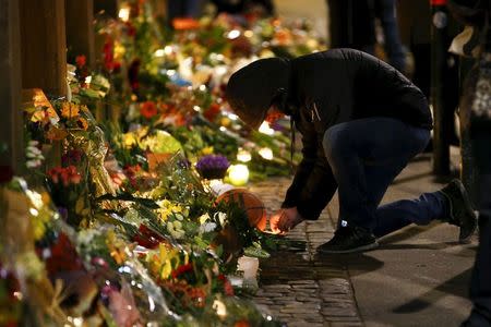 A man lights a candle at a memorial for the victims of the deadly attacks in front of the synagogue in Krystalgade in Copenhagen, in this February 15, 2015 file photo. REUTERS/Leonhard Foeger