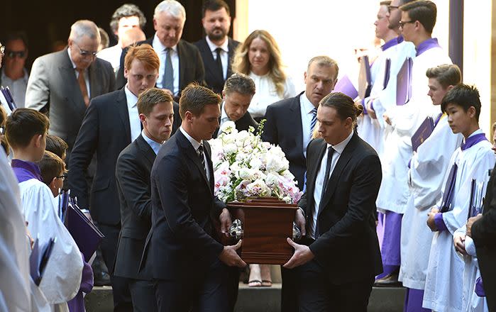 The sons of Rebecca Wilson, Tom and Will, along with her journalist brother Jim, (second right), carry the casket during her funeral service. Image: AAP