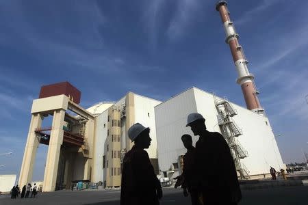 Iranian workers stand in front of the Bushehr nuclear power plant, about 1,200 km (746 miles) south of Tehran October 26, 2010. REUTERS/Mehr News Agency/Majid Asgaripour/Files