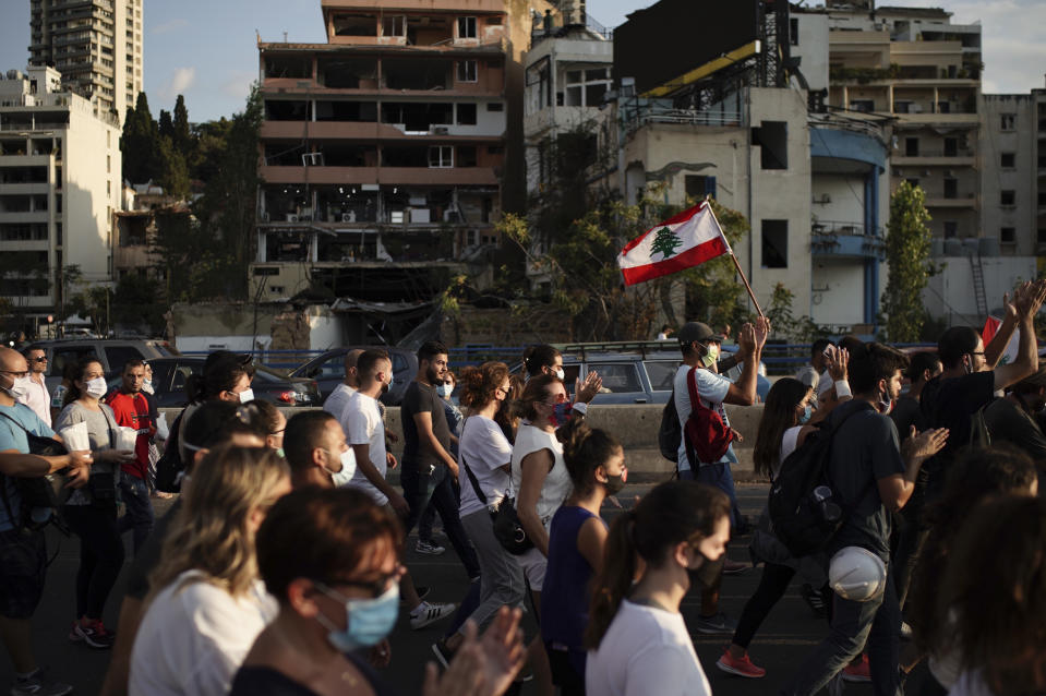 People march in honor of the victims of the last week's explosion that killed over 150 people and devastated the city, near the blast site in Beirut, Lebanon, Tuesday, Aug. 11, 2020. (AP Photo/Felipe Dana)