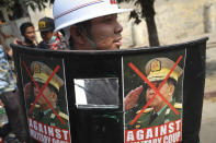 A protester holds a makeshift shield with photos denouncing coup leader Min Aung Hlaing during a demonstration in Mandalay, Myanmar, Saturday, March 6, 2021. The U.N. special envoy for Myanmar on Friday called for urgent Security Council action, saying about 50 peaceful protesters were killed and scores were injured in the military's worst crackdowns this week. (AP Photo)