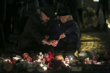 People light a candle as they arrive at Dvortsovaya Square to commemorate victims of the air crash in Egypt in St. Petersburg, Russia, November 3, 2015.REUTERS/Peter Kovalev