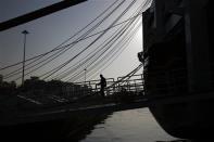 A crew member is silhouetted as he walks on the ramp of an anchored ferry-boat during a general labour strike at Piraeus port, near Athens April 9, 2014. REUTERS/Yorgos Karahalis