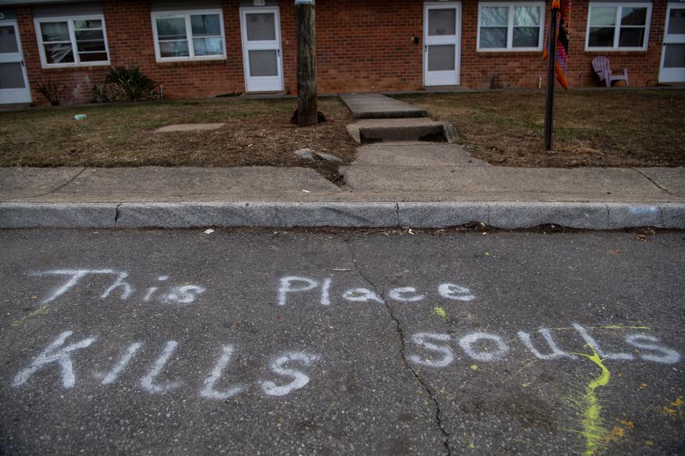"The place kills souls" is seen spray painted on a street in Deaverview Apartments in January. At one of the apartments behind the paint, Jodi Davis claims she was violently assaulted by a man with prior charges of assaulting females in the public housing neighborhood.