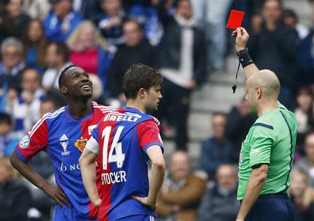 Referee Patrick Graf (R) shows a red card to FC Basel's Giovanni Sio (L) next to Valentin Stocker during their Swiss Cup final soccer match against FC Zurich in the Stade de Suisse stadium in Bern April 21, 2014. REUTERS/Ruben Sprich