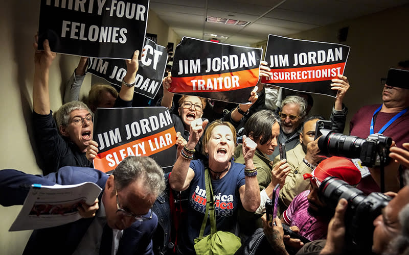 Protesters pack a hallway and hold signs that read "Jim Jordan traitor" and "Jim Jordan insurrectionist"