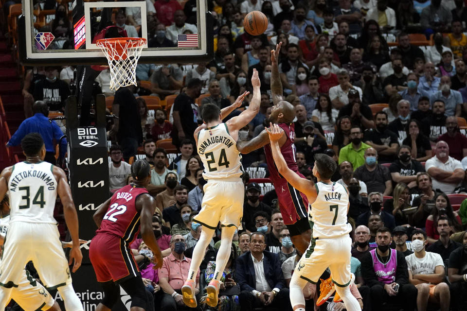 Miami Heat forward P.J. Tucker, second from right, shoots as Milwaukee Bucks guard Pat Connaughton (24) and guard Grayson Allen (7) defend during the first half of an NBA basketball game Thursday, Oct. 21, 2021, in Miami. (AP Photo/Lynne Sladky)