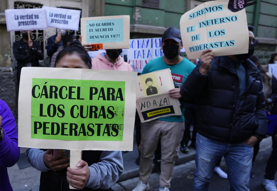 People protest with signs that read in Spanish "Prison for pedophile priests" outside the Bolivian Archbishopric office in La Paz, Bolivia, Friday, May 19, 2023. Milton Murillo, a Bolivian priest, has been remanded in custody on suspicion of abusing seminarians a decade ago, shortly after news broke of what has turned out to be the largest pedophilia scandal in the Andean country’s history, involving the deceased Jesuit priest. (AP Photo/Juan Karita)