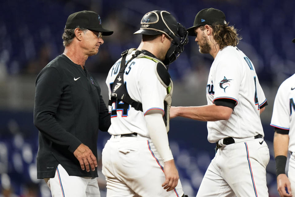 Miami Marlins relief pitcher Steven Okert, right, hands the ball to manager Don Mattingly, left, as he is removed during the eighth inning of the team's baseball game against the Chicago Cubs, Wednesday, Sept. 21, 2022, in Miami. The Cubs won 4-3. (AP Photo/Lynne Sladky)