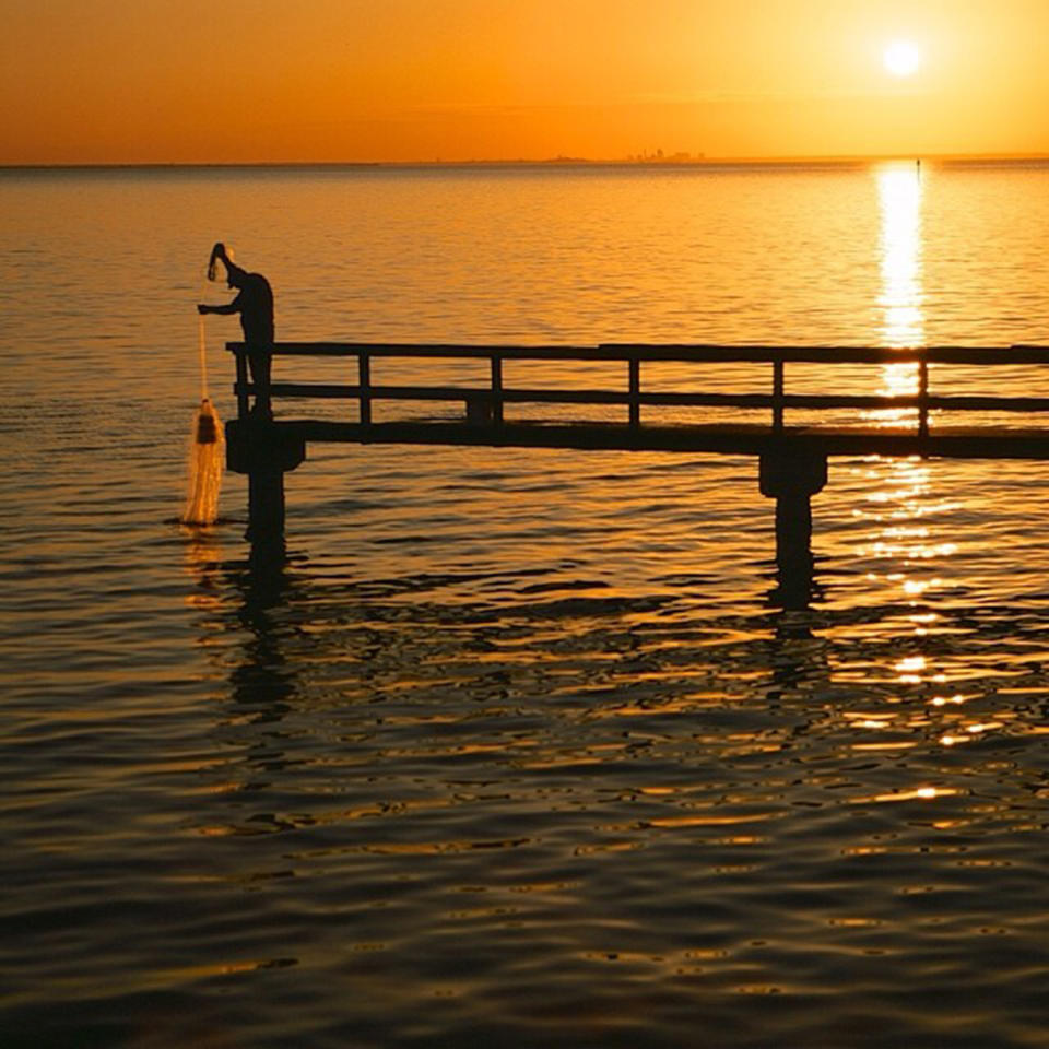 <p>Casting a net off a pier on the Mobile Bay Basin. (Photo: Mobile Baykeeper Swimmable Water Weekend Photo Contest) </p>