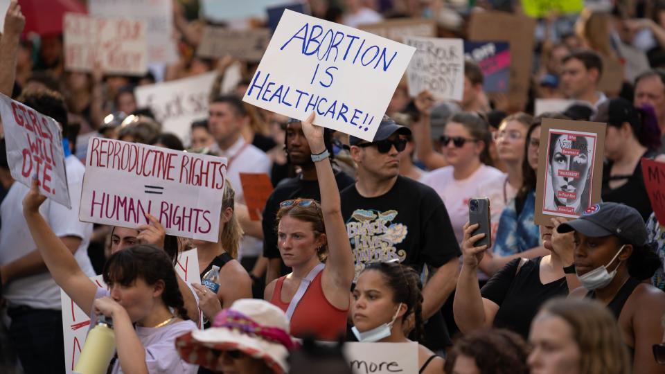 A crowd is seen holding hand-hold signs.