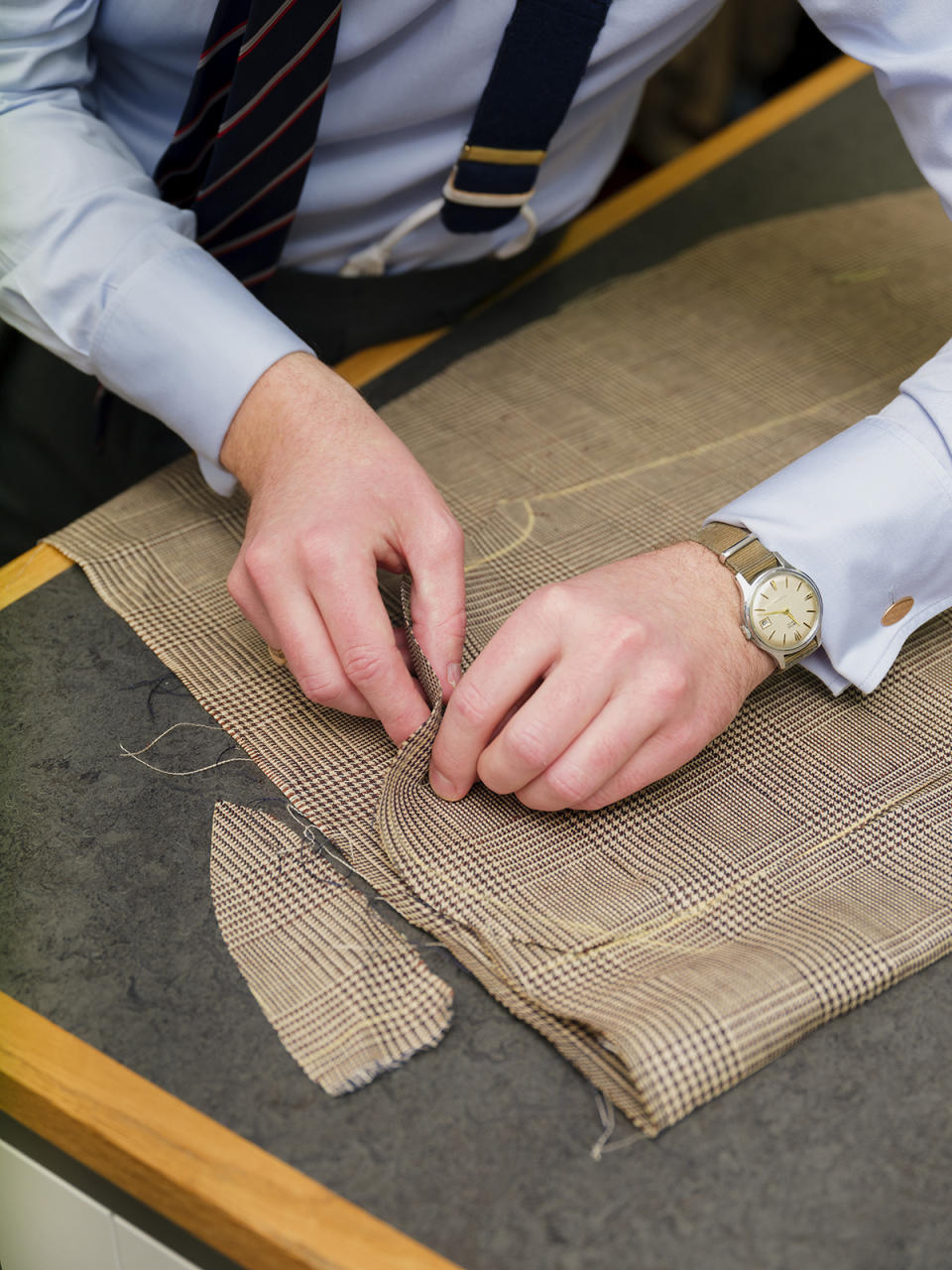One of the bespoke tailors works on a linen suit at Bourdon House.