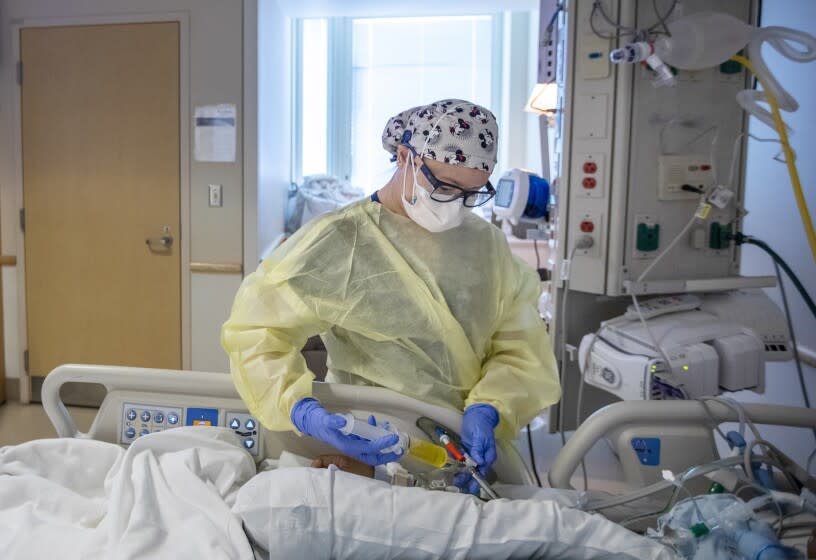 TORRANCE, CA - JANUARY 11: Registered nurse Anh Bui, is working with a Covid19 positive patient in the ICU at Providence Little Company of Mary Medical Center on Tuesday, Jan. 11, 2022 in Torrance, CA. (Francine Orr / Los Angeles Times)