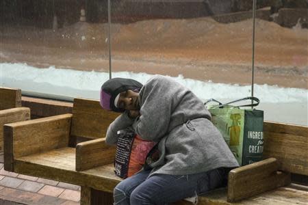 A woman sleeps on a subway bench during a winter storm in New York January 3, 2014. REUTERS/Zoran Milich