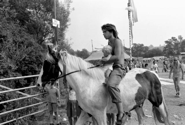 A festival-goer attends Glastonbury on horseback with a baby in the 1980s.