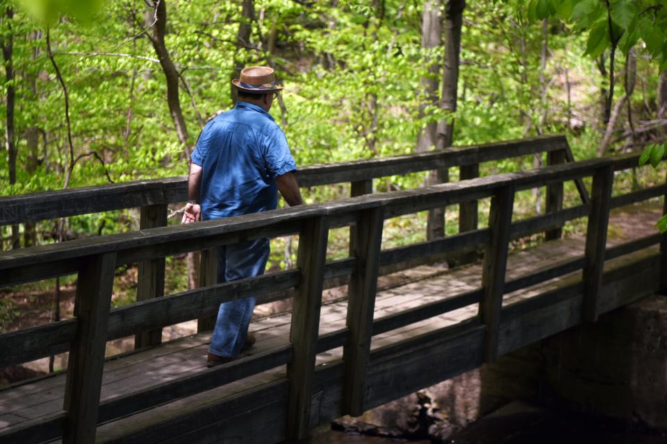 Tom Meyers crosses a bridge over Macfadden's Pond in Englewood. As a child Meyers and his friends rode bikes in the area now designated the Flat Rock Brook Nature Center.