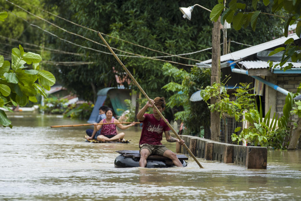 <p>Residents make their way through a flooded road in Taungnu township of Bago region in Myanmar on Aug. 31, 2018. (Photo: Ye Aung Thu/AFP/Getty Images) </p>