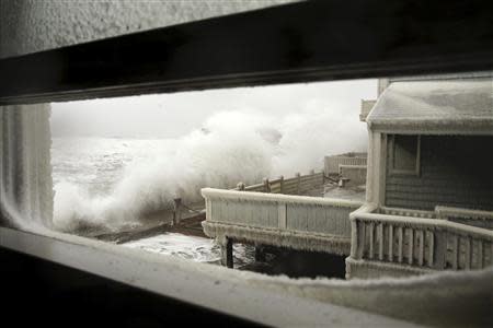 Waves crash into houses on Lighthouse Road during a winter nor'easter snow storm in Scituate, Massachusetts January 3, 2014. REUTERS/Dominick Reuter