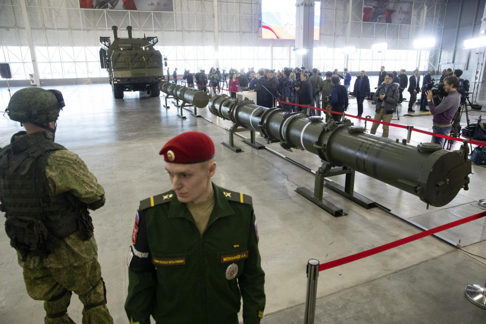 Russian military officers stand by as the 9M729, center, its launcher, left, and the 9M728, right, land-based cruise missiles are displayed in Kubinka outside Moscow, Russia, Wednesday, Jan. 23, 2019. The Russian military on Wednesday rolled out its new missile and spelled out its specifications, seeking to dispel the U.S. claim that the weapon violates a key nuclear arms pact. (AP Photo/Pavel Golovkin)