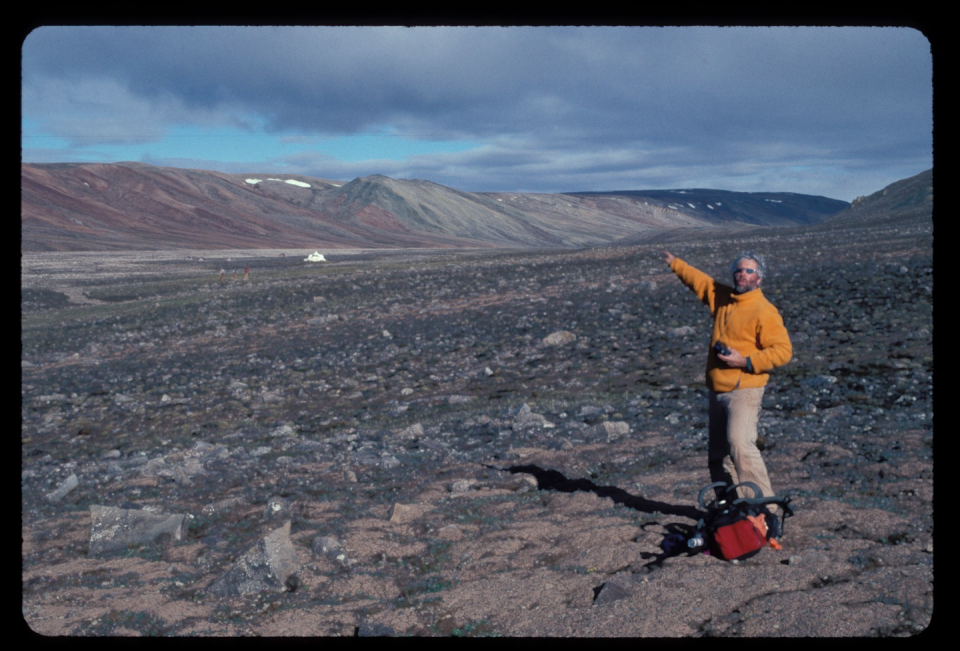 Neil Shubin, who found the fossil, pointing across the valley to the site where <em>Qikiqtania</em> was discovered on Ellesmere Island. Neil Shubin, <a href="http://creativecommons.org/licenses/by-nd/4.0/" rel="nofollow noopener" target="_blank" data-ylk="slk:CC BY-ND;elm:context_link;itc:0;sec:content-canvas" class="link ">CC BY-ND</a>