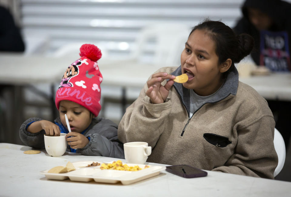 A migrant mother and her child, from El Salvador, eat breakfast at a government-run shelter in Ciudad Juarez, Mexico, on Sunday, Dec. 18, 2022. (AP Photo/Andres Leighton)