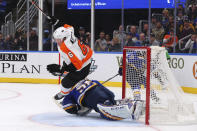 Philadelphia Flyers defenseman Travis Sanheim (6) trips over St. Louis Blues goalie Jordan Binnington (50) during the third period of an NHL hockey game Wednesday, Jan. 15, 2020 in St. Louis. (AP Photo/Dilip Vishwanat)